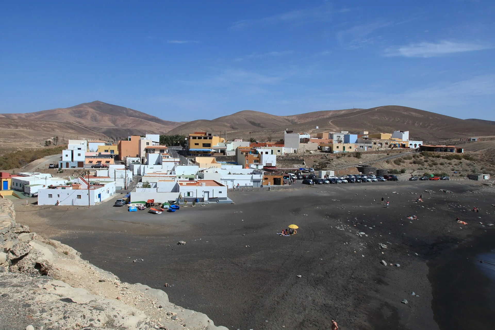 Playa de arena volcánica negra en Ajuy, Fuerteventura, con acantilados y la entrada a las cuevas de Caleta Negra