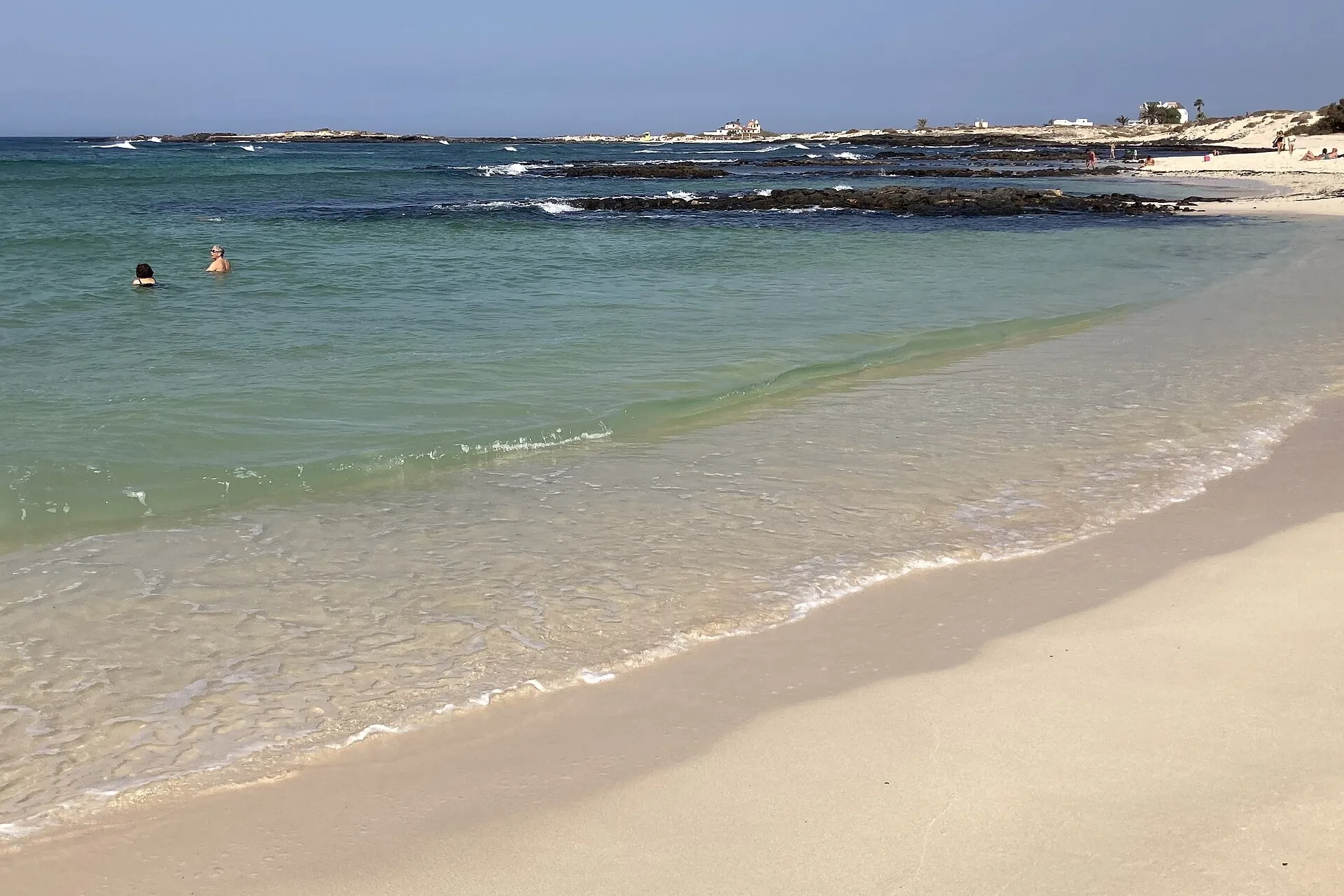 Ruhige türkisfarbene Lagune der Playa de la Concha in El Cotillo, umschlossen von einem hufeisenförmigen Vulkanriff