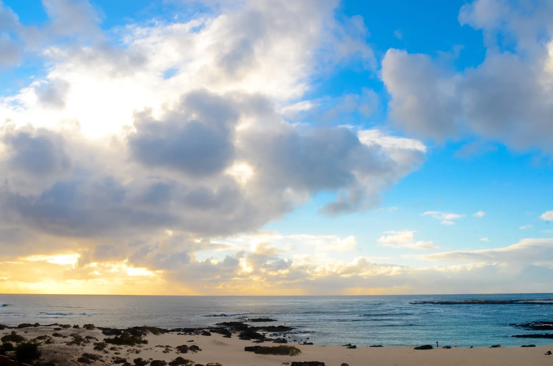 Shallow turquoise lagoon at El Cotillo with pale sand and dark volcanic reef