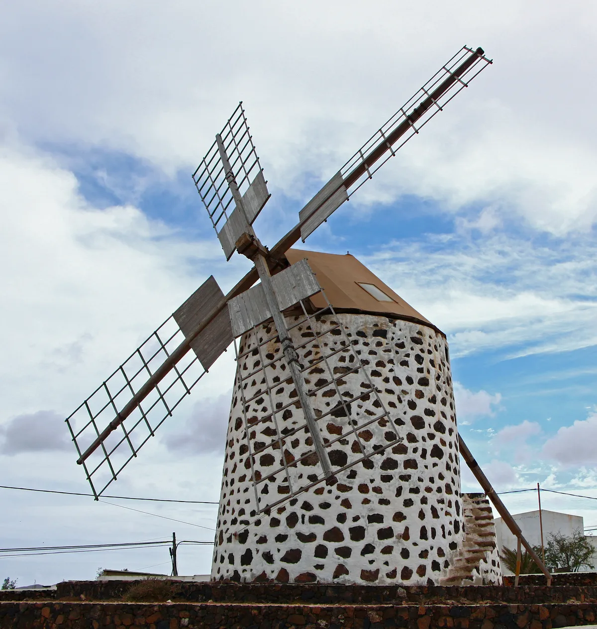 Traditional stone gofio windmill (molino) in Lajares, its wooden sails outlined against the sky