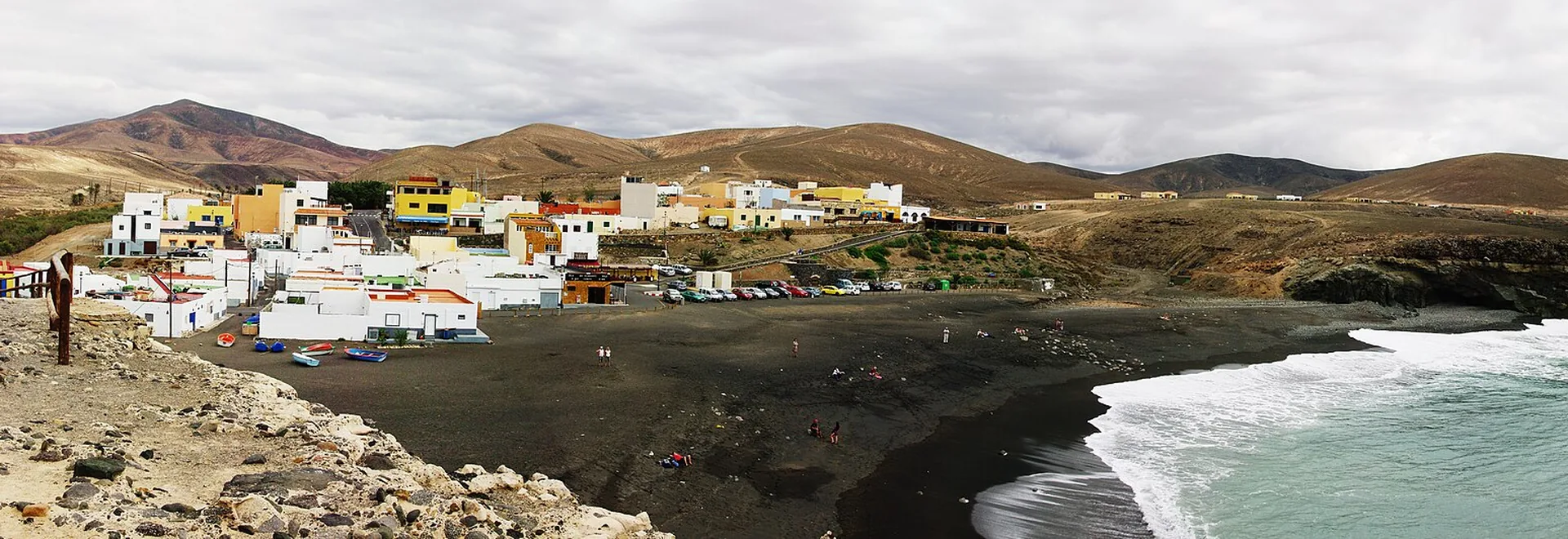 Playa de arena volcánica negra en Ajuy, Fuerteventura, con acantilados y la entrada a las cuevas de Caleta Negra