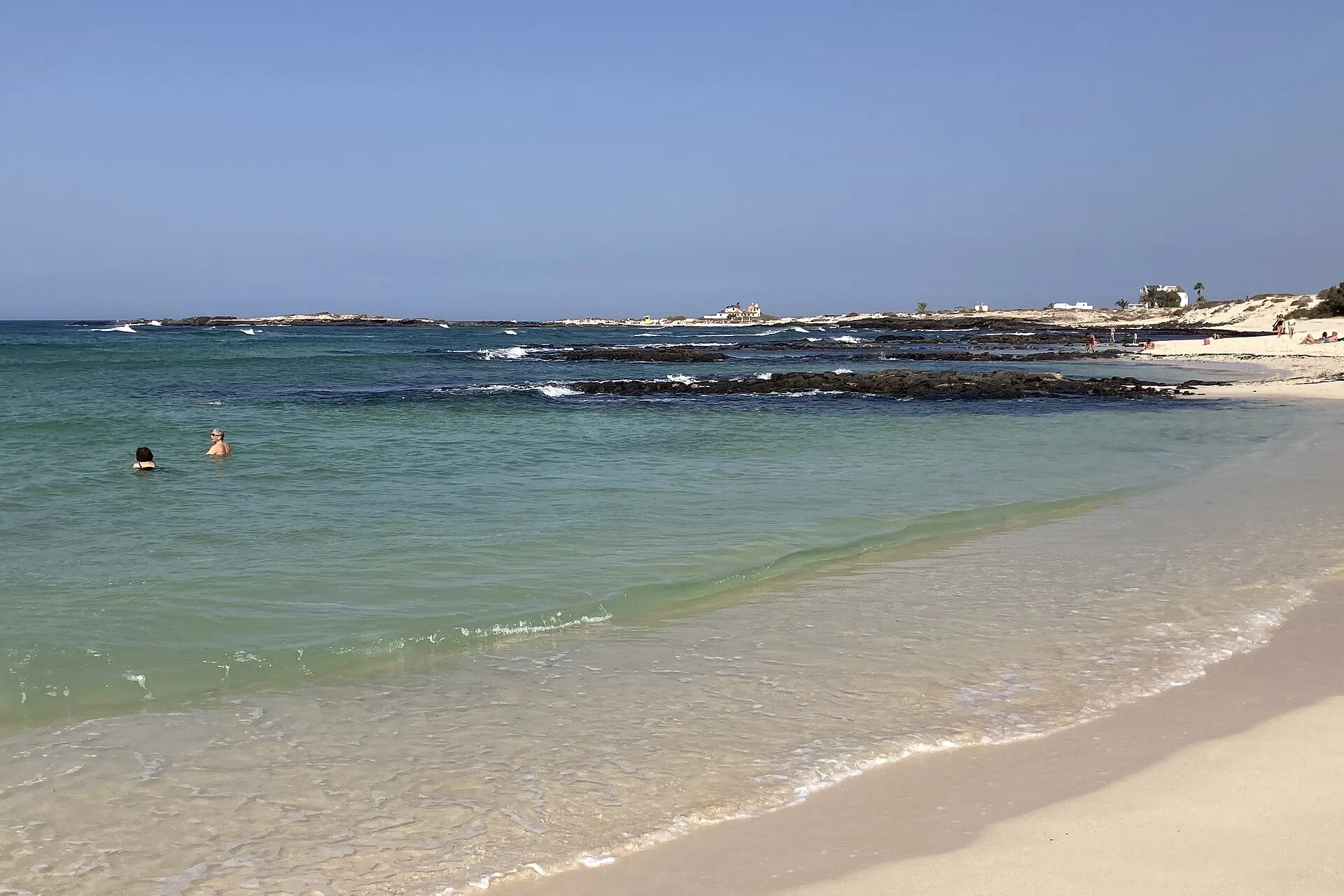 Ruhige türkisfarbene Lagune der Playa de la Concha in El Cotillo, umschlossen von einem hufeisenförmigen Vulkanriff